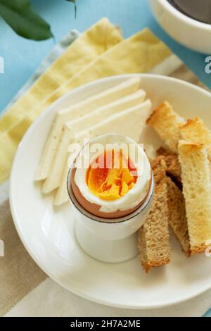 Breakfast with boiled eggs, cheese, bread toast and coffee. Rustic style. Stock Photo
