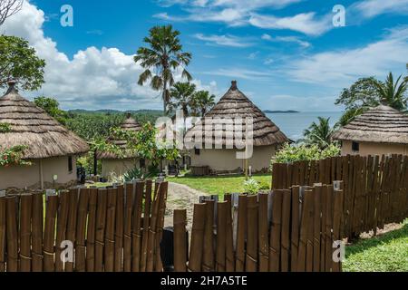 African bungalow with thatched roof and built in old tradition on a hill in Axim overlooking the sea located in Ghana West Africa Stock Photo