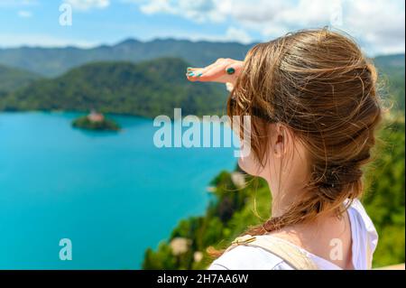 Tourist woman looking ahead to the horizon and enjoying view of lake Bled, Slovenia Stock Photo