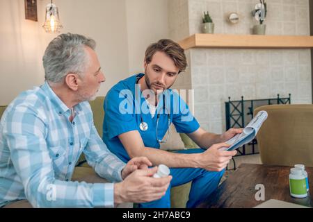 Gray-haired patient talking to his doctor about prescription drugs Stock Photo