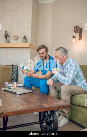 Serious man listening to doctors advice about dietary supplements Stock Photo