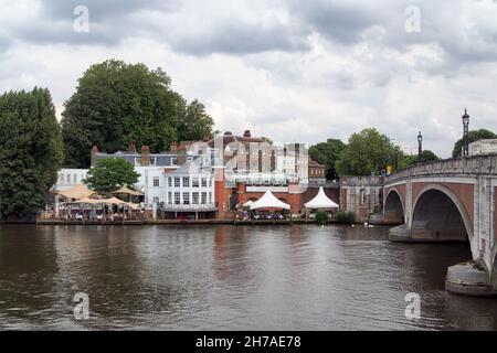 MOLESEY, SURREY, UK - JULY 09, 2021:  View across the River Thames of Hampton Court bridge and the Mitre Hotel in East Molesey Stock Photo