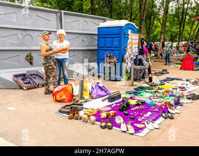 Women selling second-hand shoes on the ground in outdoor Udelka Udelnaya flee market, the largest in city of St Petersburg, Russia Stock Photo