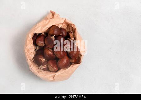 Top view of fresh chestnuts on neutral grey background with copy space Stock Photo
