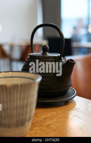 Asian teapot and cup on a restaurant table. Black teapot Stock Photo