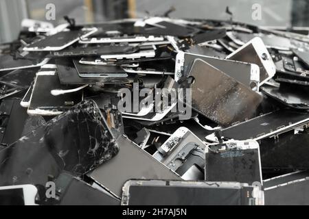 Prague, CZ - 13 January 2021: A heap with the Apple iPhone broken screens lying one on top of another. Devices are prepared for utilization. Editorial Stock Photo