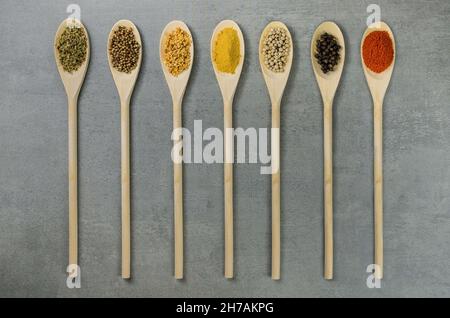 Various spices in wooden spoons side by side seen from above Stock Photo