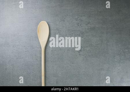Empty wooden spoon on gray concrete background. Stock Photo