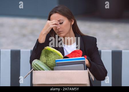 Upset woman got fired from an office job. Dismissal from work or job loss. Stock Photo