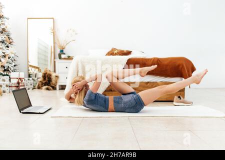 Fit woman doing twists exercise workout at home. Stock Photo