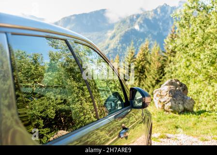 Close-up of car in the mountain with tree reflection on window glass Stock Photo