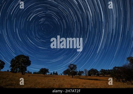 Star trails over rural Australian landscape illuminated by rising moon