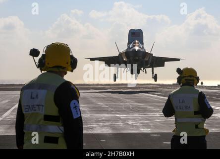 U.S. Marine Corps Brig. Gen. Simon Doran, US Senior National Representative to the United Kingdom (UK) Carrier Strike Group, lands an F-35B Lightning II on the flight deck of HMS Queen Elizabeth in the Mediterranean Sea on November 20th, 2021. This deployment demonstrates that the United States and the UK are united in our efforts to ensure security and freedom of the seas, that our maritime power projection capabilities are interoperable, complementary, and global. Stock Photo