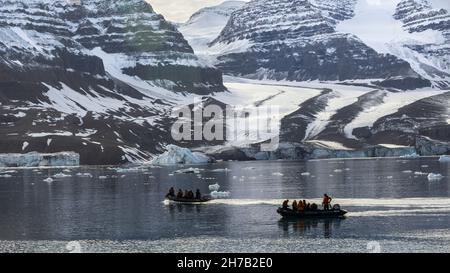 Zodiacs by the north arm of the Bredegletcher, Vikingebugt Inlet, Scoresby Sund, Greenland Stock Photo