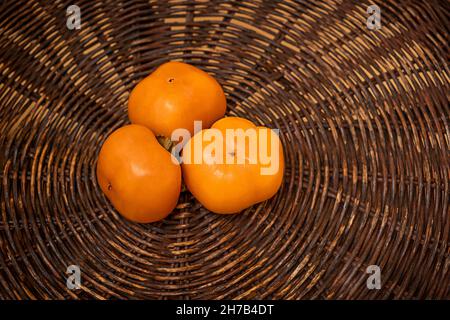 juicy frash orange date-plum. persimmon on wood texture. brown backgraund Stock Photo