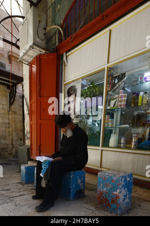 An Ethiopian  Orthodox priest sitting outside a shop in the Muristan, Christian quarter in the old city of Jerusalem. Stock Photo