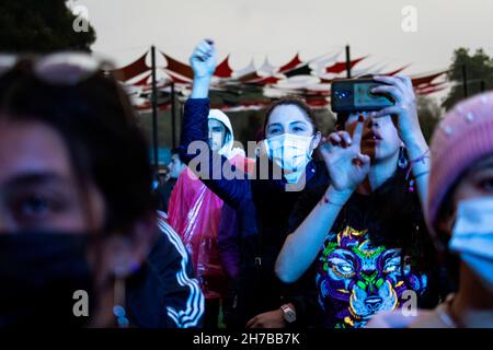 Fans enjoy bands during the first day of the 'IDARTES 10 AÑOS' musical festival that carries rock, metal, punk, salsa and hip hop music across two weekends (20-21 and 27-28 of November) at the Simon Bolivar Park and Scenario 'La Media Torta' in Bogota, Colombia on November 20, 2021. Stock Photo