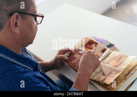 Older man viewing photo album at home Stock Photo