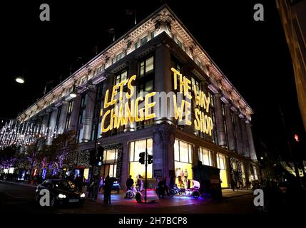 London, UK. 21st Nov, 2021. Photo take on Nov. 21, 2021 shows a building with light writing 'LET'S CHANGE THE WAY WE SHOP' in central London, Britain. Credit: Li Ying/Xinhua/Alamy Live News Stock Photo