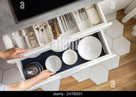 Top view modern housewife tidying up kitchen cupboard during general cleaning or tidying up Stock Photo