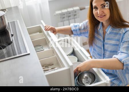 Top view modern housewife tidying up kitchen cupboard during general cleaning or tidying up Stock Photo