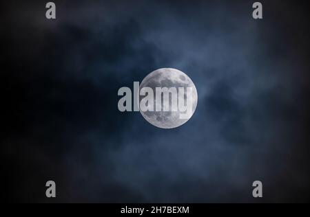 Full moon against the black cloudy night sky Stock Photo
