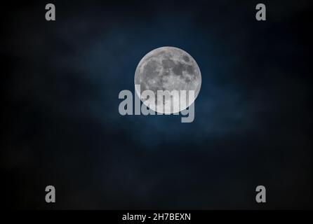 Full moon against the black cloudy night sky Stock Photo