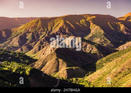 The folds of the mountains create an amazing pattern illuminated by the rays of the setting sun. The play of light and shadow Stock Photo