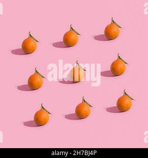 Fruit minimalistic pattern of fresh tangerine on pink background Stock Photo