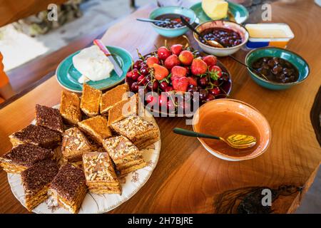 A lot of sweet foods on the table - cakes, honey and fruits - contain an excess of fast sugars and carbohydrates Stock Photo