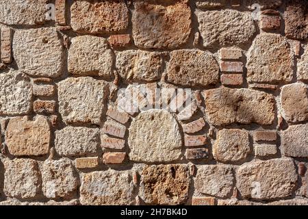 Figured old masonry made of blocks of different sizes in cement mortar. Stock Photo