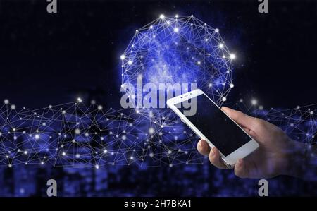 The modern concept of the cyberbrain. Hand hold white smartphone with digital hologram Artificial intelligence sign on city dark blurred background. V Stock Photo