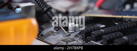 Master in gloves with equipment is testing computer motherboard Stock Photo