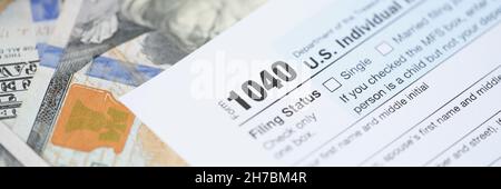 Individuals tax return form 1040 and dollars are on table Stock Photo