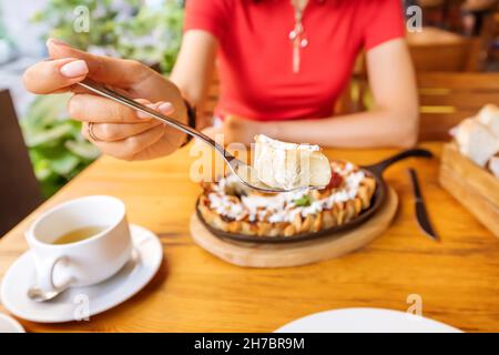 Woman eating opened manti or dumplings with white sauce in restaurant. Traditional cuisine of Oriental and Turkic people Stock Photo