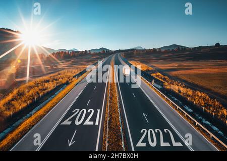 Driving on open road at beautiful sunny day to new year 2022. Aerial view Stock Photo