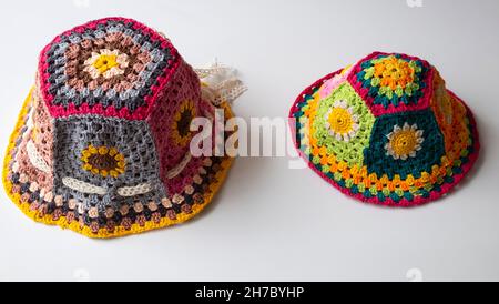Top view handmade product to make spring present, colorful bucket hat with many piece link together, cute crochet hat from yarn on white background Stock Photo