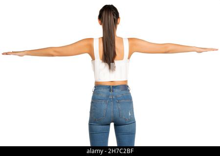 rear view of a young beautiful woman with outstretched arms and ponytail on a white background Stock Photo