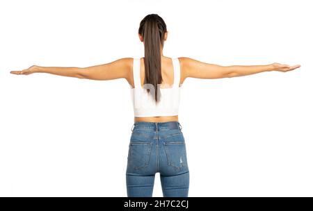 rear view of a young beautiful woman with outstretched arms and ponytail on a white background Stock Photo