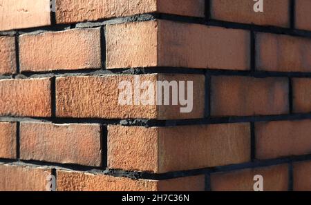 Brown brick wall texture, background. Uneven surface of brick lying. The corner of a wall or building. Abstract brick background. Decorative wall Stock Photo