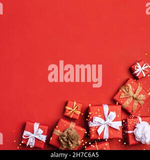 Gift boxes with white and brown bows on a red backdrop. Stock Photo