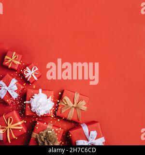 Gift boxes with white and brown bows on a red backdrop. Stock Photo