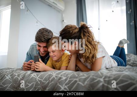 Happy family using digital technology decives for playing watching movies, relaxing at home. Stock Photo