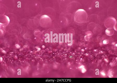 Pink glitter, blurred effect. Glowing holiday light circles are created from bokeh in the camera and lens. Background for design. Christmas background Stock Photo