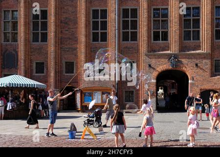 TORUN, POLAND - 07 August 2021: The juggler is entertaining children with big baubles on Torun market square Stock Photo