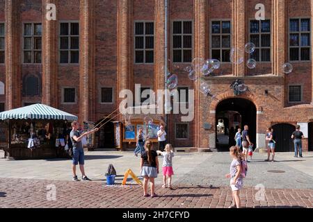 TORUN, POLAND - 07 August 2021: The juggler is entertaining children with big baubles on Torun market square Stock Photo