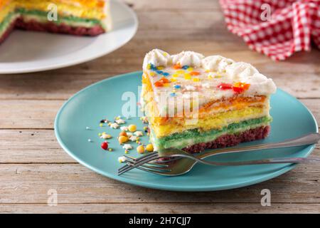 Rainbow layer cake on wooden table Stock Photo