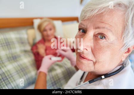 A doctor or nurse does a CRP rapid test on a sick senior citizen in a nursing home Stock Photo