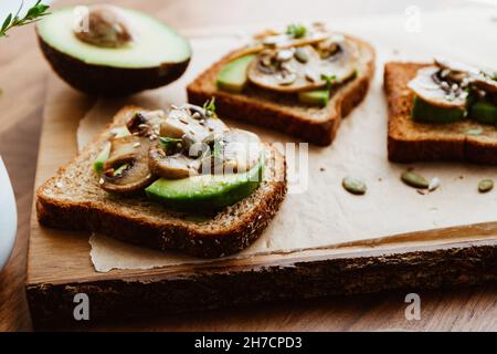 Toasts with fried mushrooms and avocado. Healthy fitness food. Stock Photo