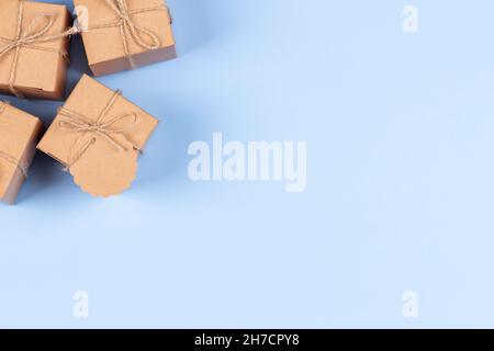 Top view to small brown present gift boxes. One small box with blank label tag Stock Photo